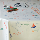 white PVC Table Cloth that you decorate yourself. the Table Cloth changes as time goes by and more and more notes, drawings and decorations are added.